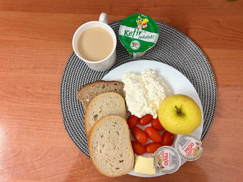 Na zdjęciu : Kefir 2% tł, Kawa zbożowa z mlekiem/p, Chleb mieszany pszenno-żytni, Chleb Graham, Masło extra 82%, Miód, Twarożek, Jabłko, Pomidorki koktajlowe